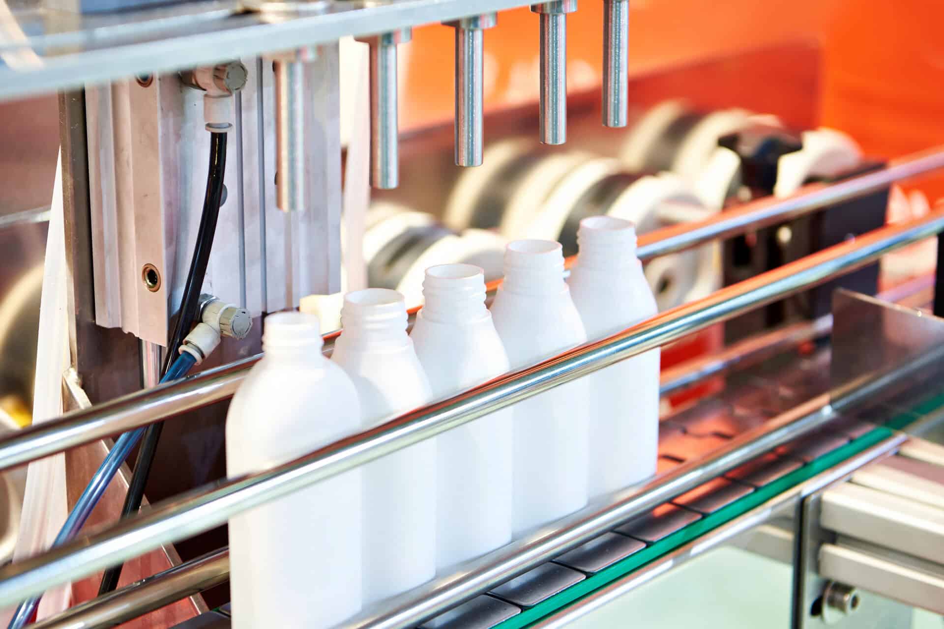 Witte flessen op een geautomatiseerde productielijn